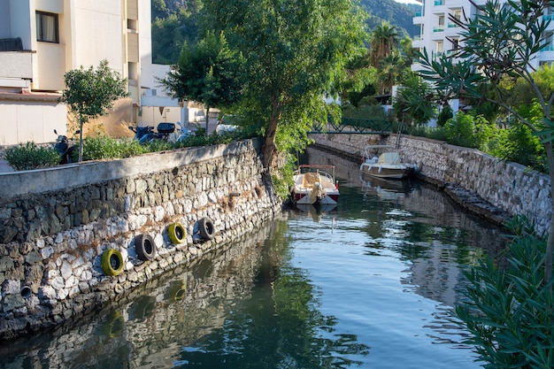 Klein waterkanaal in Turkse stad Stadslandschap met kanaalboten en kleurrijke bezinningen op het water