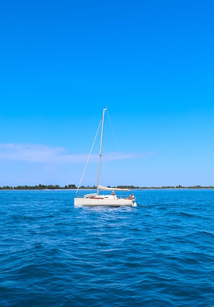 Klein wit schip op zee op de achtergrond vergiftigen in Venetië