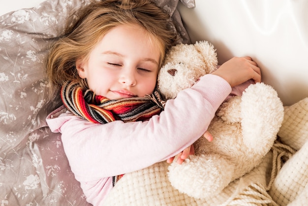 Klein ziek meisje slaap knuffelen teddybeer