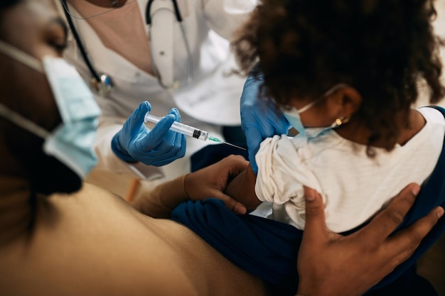 Klein zwart meisje dat vaccin krijgt tijdens COVID19-pandemie