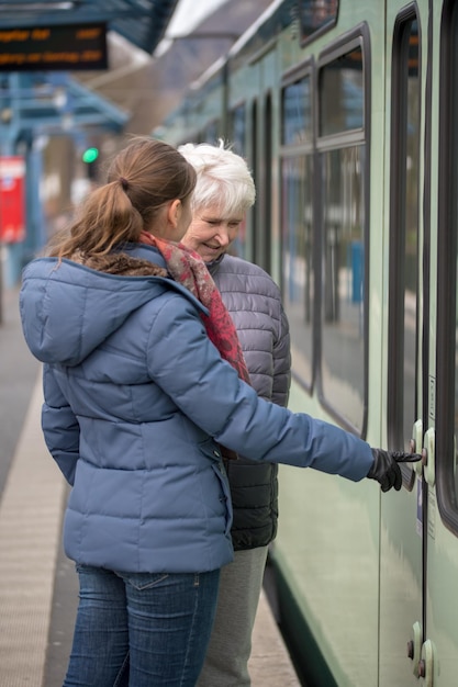 kleindochter die oma leert de deur van de trein te openen