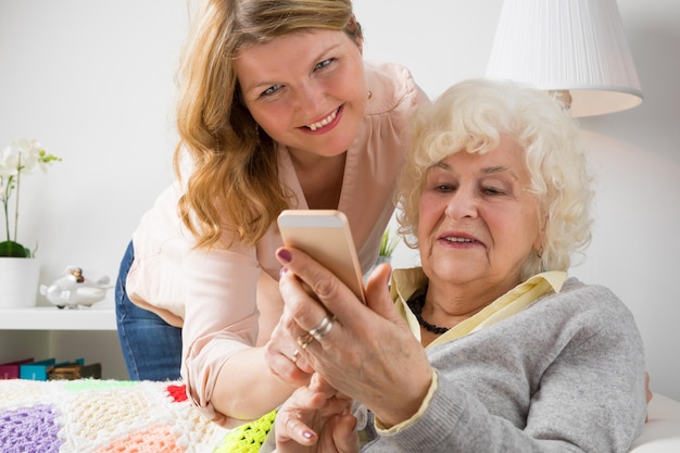 Kleindochter die oma leert hoe ze een smartphone moet gebruiken