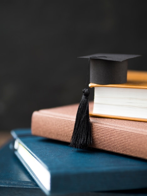 Foto kleine afstuderen cap op stapel boeken