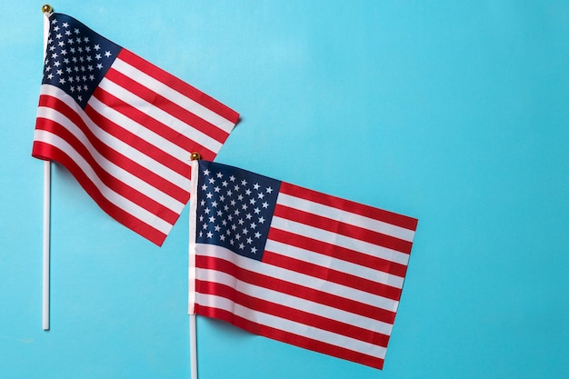 Kleine Amerikaanse nationale vlaggen geïsoleerd op blauwe achtergrond met copyspace Ruimte voor tekst