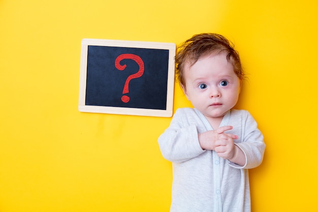 Kleine baby met zwarte bord en rode vraag