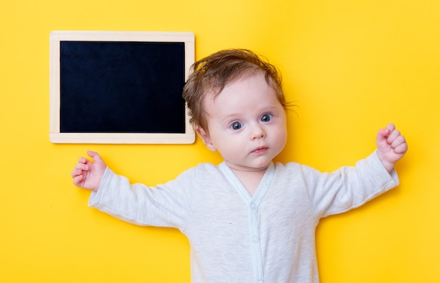 Kleine baby met zwarte bord