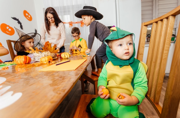 Kleine babyjongen in groen fancy kostuum zit en huilt