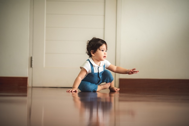 Kleine babyjongen kruipen op de vloer, schattig kind, mooie zoon, vaders hand vasthouden en lopen. lachende baby, familie happy time concept. lief en schattig.