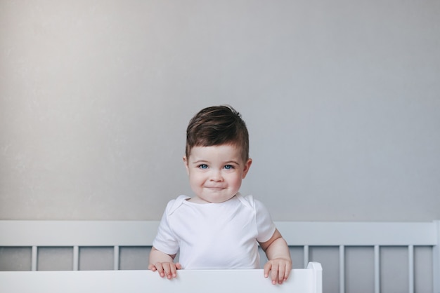 Kleine babyjongen lacht op een wit bed gelukkige kindertijd concept peuter met mooie ogen