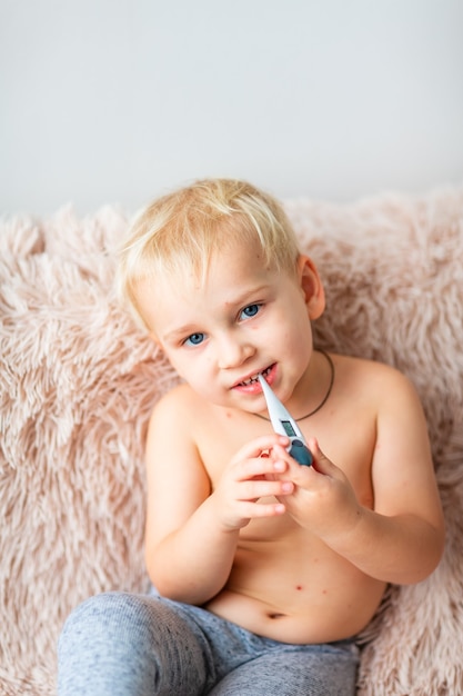 Kleine babyjongen met Varicella-virus of Waterpokken-bellenuitslag die zijn temperatuur thuis controleert