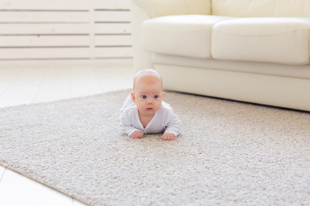 kleine babyjongen of meisje kruipen op de vloer thuis