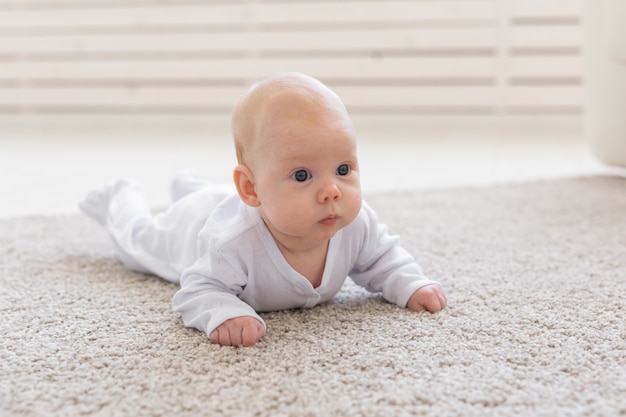 kleine babyjongen of meisje kruipen op de vloer thuis