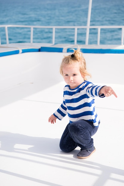 Kleine babykapitein op boot op nautische mode voor zomercruises