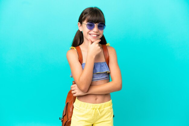 Kleine blanke jongen gaat naar het strand geïsoleerd op een blauwe achtergrond met een bril en glimlachen