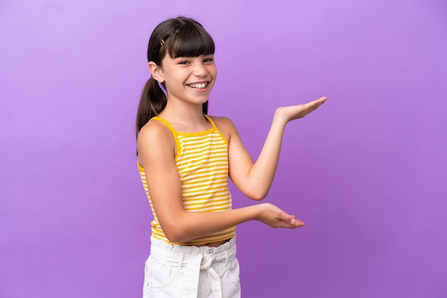 Kleine blanke jongen geïsoleerd op een paarse achtergrond die zijn handen naar de zijkant uitstrekt om uit te nodigen om te komen