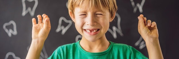 Kleine blanke jongen houdt een gevallen melk tand tussen zijn vingers en lacht kijken in de