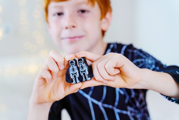 Kleine blanke jongen spelen met halloween trick or treat candy skeleton chocolade