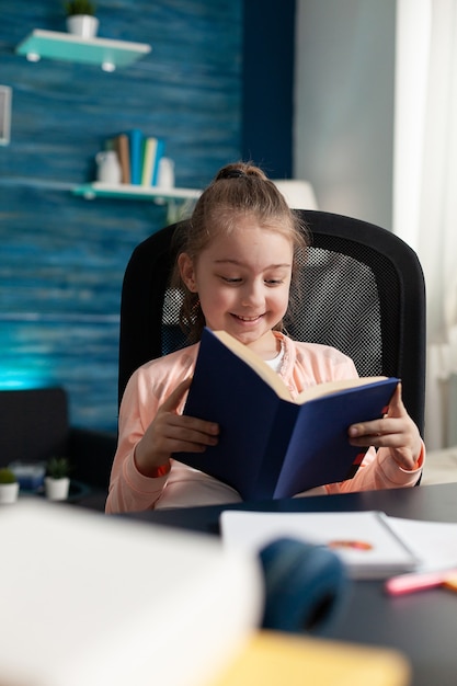 Kleine blanke student met boekleespagina's