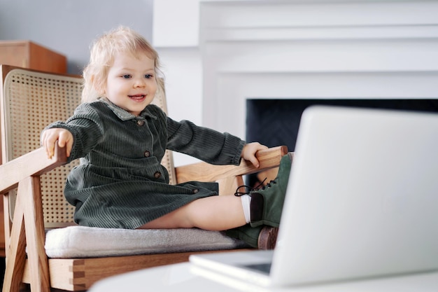 Kleine blonde babymeisje met blauwe ogen die alleen thuis met een houten speelgoed speelt Gelukkige stemming