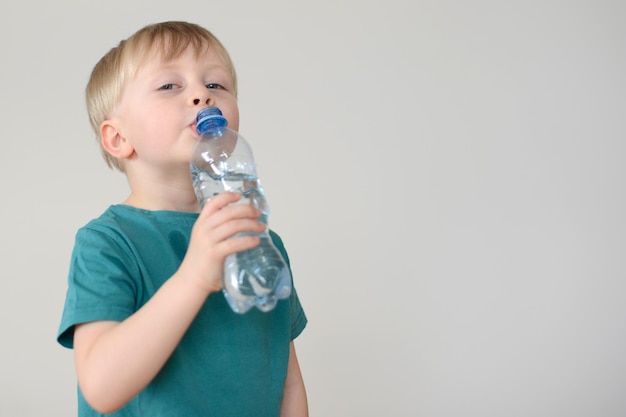 kleine blonde jongen drinkt water