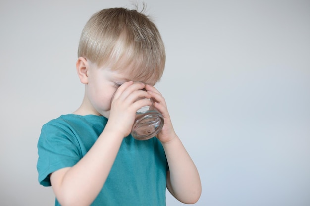 kleine blonde jongen drinkt water