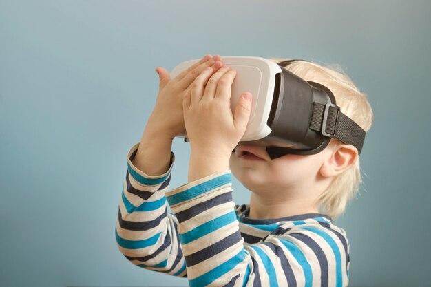 Kleine blonde jongen met een bril van virtual reality.