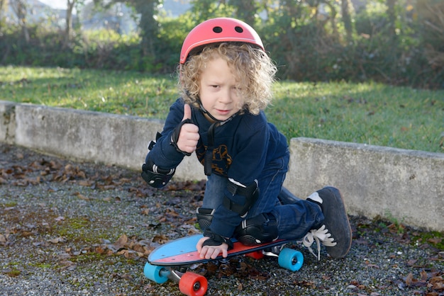 Kleine blonde jongen met skateboard