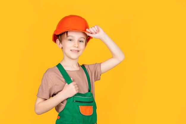 Kleine bouwer in helm. kind verkleed als werkmanbouwer. kleine jongen die helm draagt. portret kleine bouwer in veiligheidshelmen. kind bouwhelm, bouwvakker.