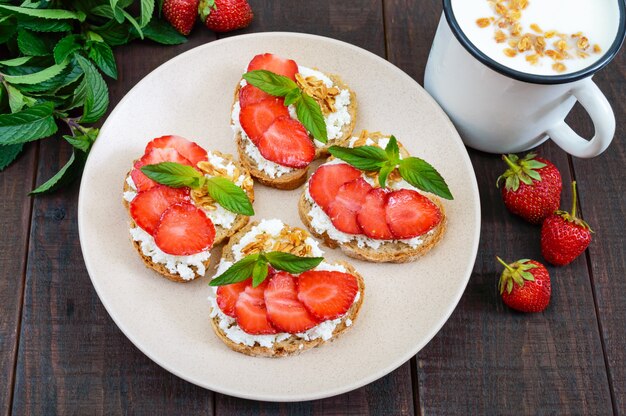 Kleine bruschetta met kwark en verse aardbeien met munt