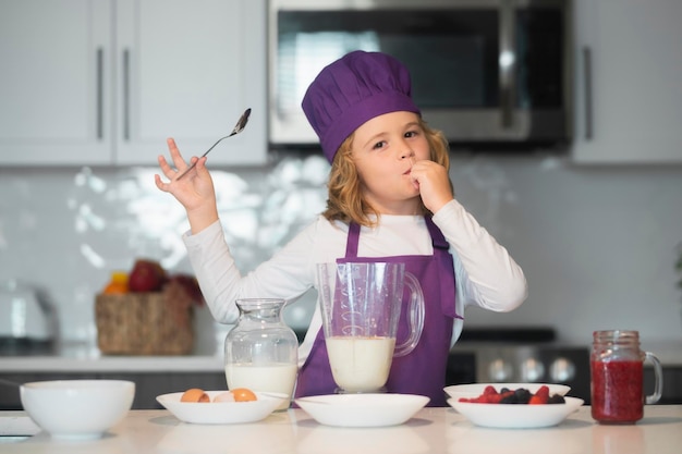 Kleine chef-kok bereidt gezonde maaltijd schattige jongen jongen in chef-kok uniform op keuken