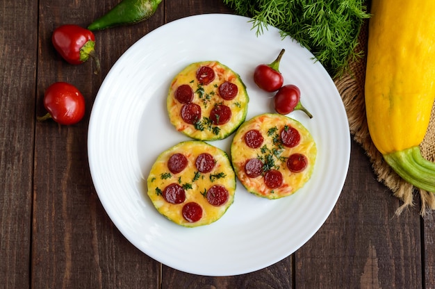 Kleine courgettepizza op de cirkels met pepperoni en mozzarella