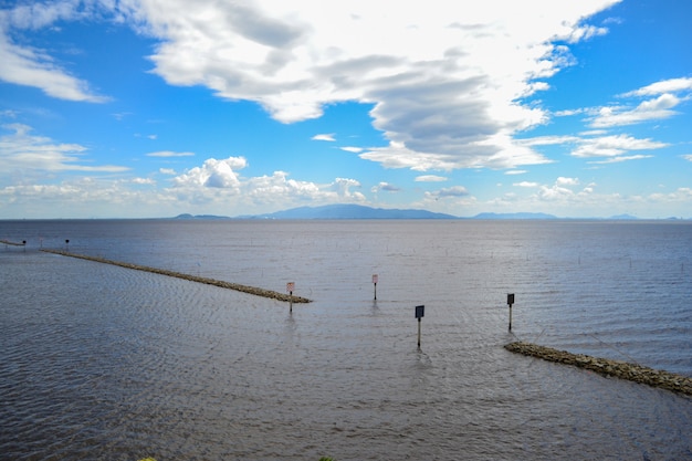 Kleine dammen in de zee en de blauwe lucht, witte wolken.