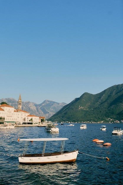 Kleine excursiebootjes liggen in de zee voor de kust van Perast Montenegro