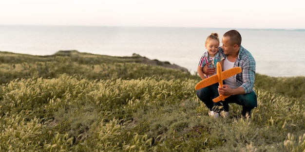 Kleine familie vader en dochter tijdens een wandeling in de zomeravond op het veld lanceren een vliegtuig liefhebbende man met een klein meisje een plek om te wandelen en een gezonde levensstijl Gelukkig familieconcept