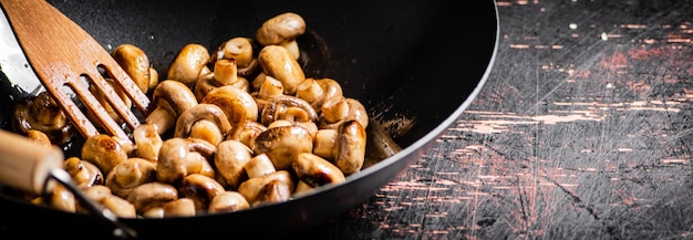 Kleine gebakken champignons in een koekenpan