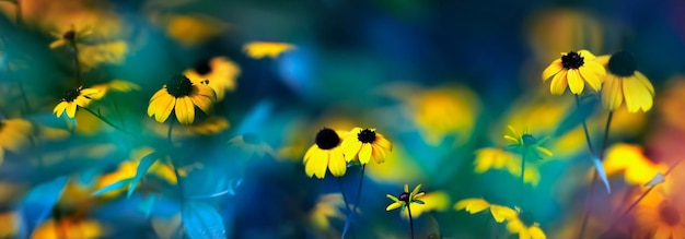Kleine gele heldere zomerbloemen op een achtergrond van blauw en groen gebladerte in een sprookjestuin Macro artistiek beeld Bannerformaat