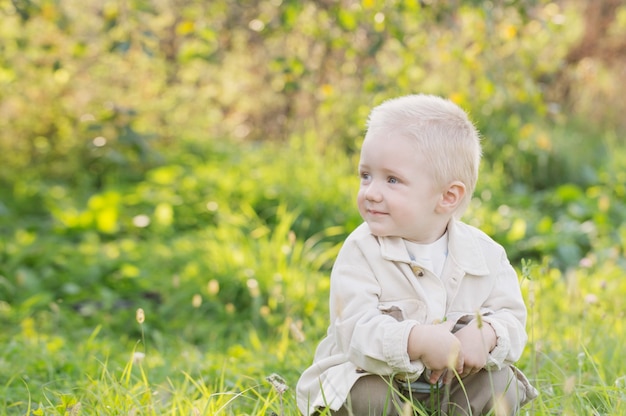 Kleine gelukkige blonde jongen buiten op zonnige zomerdag