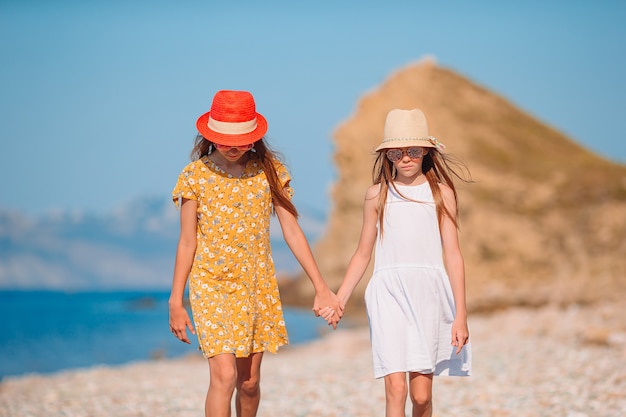 Kleine gelukkige grappige meisjes hebben veel plezier op tropisch strand samen spelen