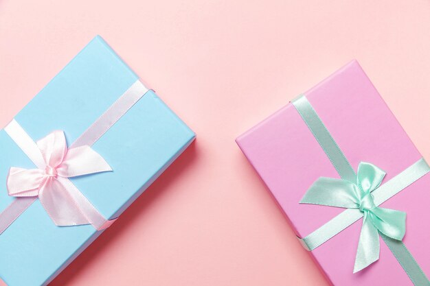 Kleine geschenkdoos verpakt roze en blauw papier geïsoleerd op roze pastel kleurrijke trendy