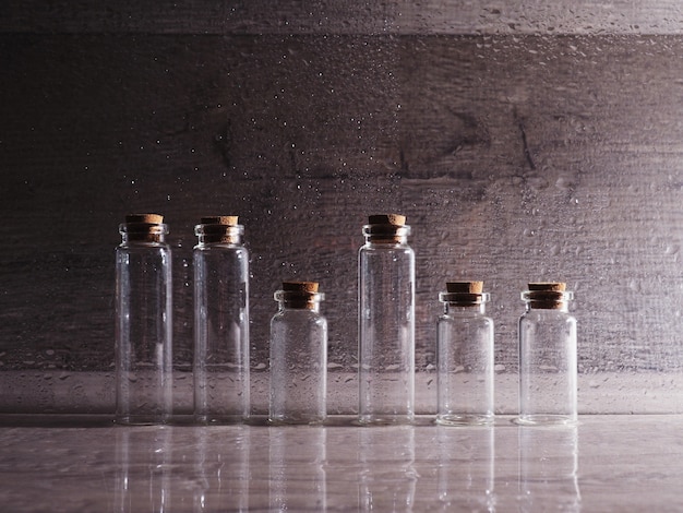 Foto kleine glazen flessen met kurken deksel. lege bellen in contourlicht