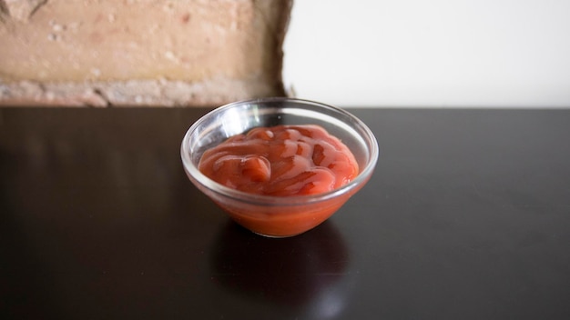 Kleine glazen kom met tomatenketchup.