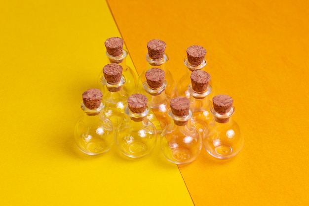 Kleine glazen potjes met stoppers op een gele en oranje achtergrond Een set ronde glaskralen