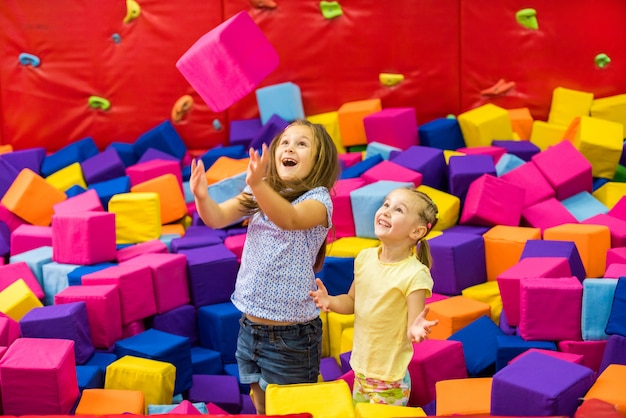 Kleine glimlachende meisjes die in het pretpark spelen