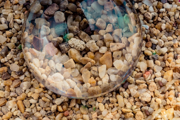 Kleine grindstenen als achtergrond onder een glas