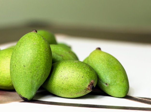 Kleine groene mango's op een houten tafel