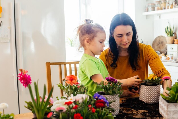 Kleine helper helpt moeder bij het planten van bloemen thuis