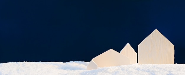 Kleine houten huizen bedekt met sneeuw op een donkere achtergrond van poolnacht