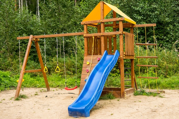 Kleine houten log speelhuis houten glijbaan op kinderspeelplaats