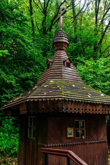 Kleine houten orthodoxe kapel bij de heilige lente in groen bos in shamordino kaluga oblast russia