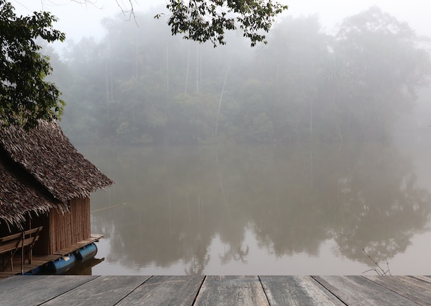 Kleine hut dichtbij meer met mist in ochtenddag